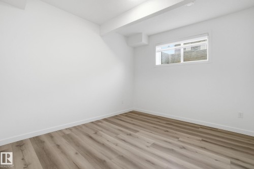 Empty room with wood finished floors and beam ceiling - 2532 210 Street, Edmonton, AB - Indoor Photo Showing Other Room