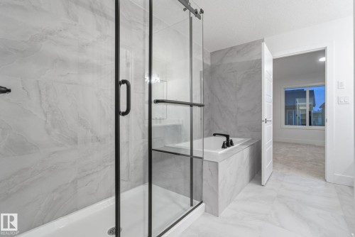 Full bath featuring a bath, a marble finish shower, and light marble finish floors - 2532 210 Street, Edmonton, AB - Indoor Photo Showing Bathroom