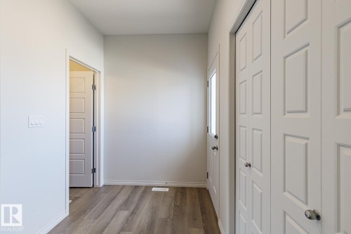 Corridor with dark wood-type flooring and baseboards - 3617 Triomphe Boulevard, Beaumont, AB - Indoor Photo Showing Other Room