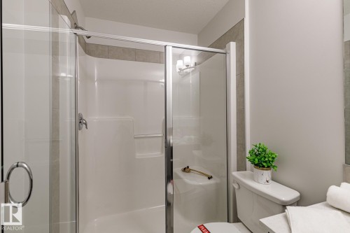 Bathroom featuring a stall shower, vanity, and a textured ceiling - 3617 Triomphe Boulevard, Beaumont, AB - Indoor Photo Showing Bathroom