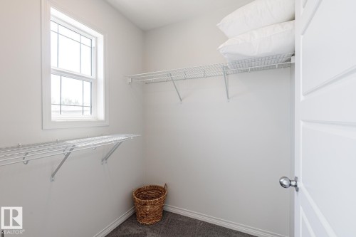 Walk in closet with dark colored carpet - 3617 Triomphe Boulevard, Beaumont, AB - Indoor With Storage