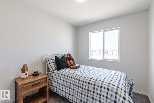 Bedroom with dark carpet and baseboards - 3617 Triomphe Boulevard, Beaumont, AB - Indoor Photo Showing Bedroom