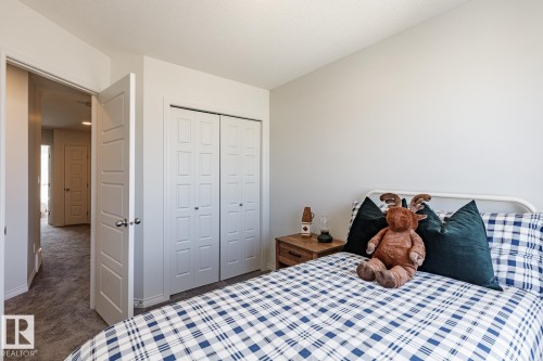 Bedroom with dark carpet and a closet - 3617 Triomphe Boulevard, Beaumont, AB - Indoor Photo Showing Bedroom