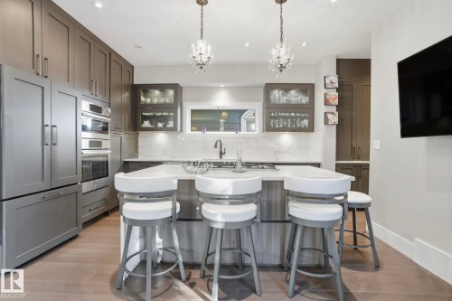 Kitchen featuring glass insert cabinets, backsplash, a breakfast bar, a center island with sink, and recessed lighting - 11121 81 Avenue, Edmonton, AB - Indoor