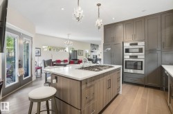 Kitchen featuring a breakfast bar area, light wood-style floors, hanging light fixtures, a center island, and recessed lighting - 