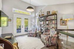 Sitting room with french doors, wood finished floors, and a high ceiling - 