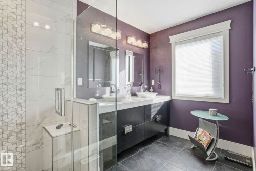 Bathroom featuring a shower stall, double vanity, and dark tile patterned floors - 11121 81 Avenue, Edmonton, AB - Indoor Photo Showing Bathroom