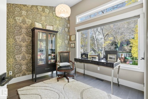 Living area featuring wallpapered walls, wood finished floors, an office area, and an accent wall - 11121 81 Avenue, Edmonton, AB - Indoor