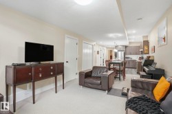 Living area featuring light carpet and a textured ceiling - 