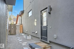 View of side of property featuring stucco siding and a gate - 
