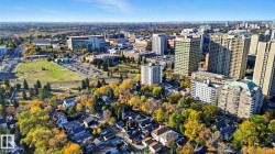 Aerial view of property's location with nearby urban area and a tree filled landscape - 