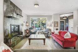 Living area featuring wood finished floors, a fireplace, and a textured ceiling - 