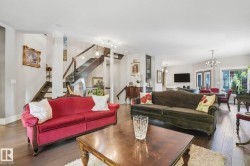Living area featuring a chandelier, stairway, and wood-type flooring - 