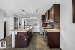 Kitchen featuring dark brown cabinetry, stainless steel appliances, light countertops, and a textured ceiling - 