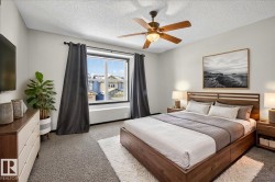 Carpeted bedroom featuring ceiling fan and a textured ceiling - 