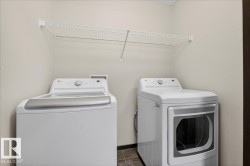 Laundry room featuring washer and dryer and dark tile patterned flooring - 