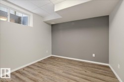 Finished below grade area with wood finished floors and a paneled ceiling - 