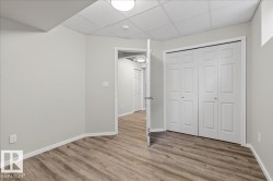 Unfurnished bedroom featuring a drop ceiling, wood finished floors, and a closet - 