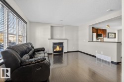 Living room featuring a glass covered fireplace, hardwood / wood-style flooring, and a textured ceiling - 