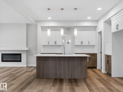 364 Bluff Cove, Leduc, AB - Indoor Photo Showing Kitchen With Fireplace