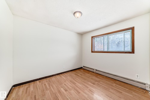 Empty room with a baseboard radiator and light wood-style flooring - 12028 87 Street, Edmonton, AB - Indoor Photo Showing Other Room