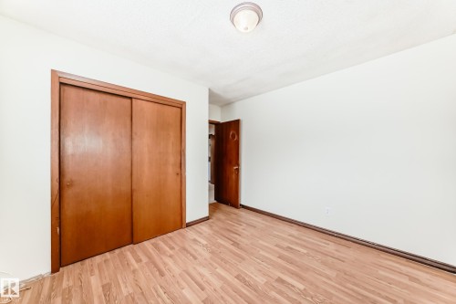Unfurnished bedroom with light wood-type flooring and a closet - 12028 87 Street, Edmonton, AB - Indoor Photo Showing Other Room