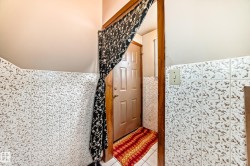 Full bathroom featuring tile walls, a wainscoted wall, light tile patterned floors, and a shower with shower curtain - 
