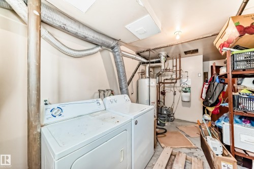 Laundry area featuring unfinished concrete flooring, washer and dryer, and water heater - 12028 87 Street, Edmonton, AB - Indoor Photo Showing Laundry Room