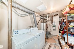 Laundry area featuring unfinished concrete flooring, washer and dryer, and water heater - 