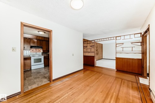 Unfurnished room with light wood-style flooring, a textured ceiling, and baseboard heating - 12028 87 Street, Edmonton, AB - Indoor Photo Showing Other Room