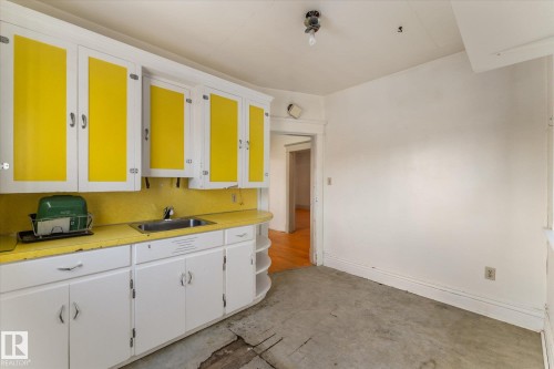 Kitchen with light countertops, white cabinets, and concrete flooring - 10921 126 Street, Edmonton, AB - Indoor