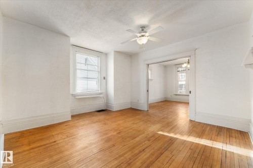 Spare room featuring a ceiling fan, light wood-style floors, and a textured ceiling - 10921 126 Street, Edmonton, AB - Indoor Photo Showing Other Room