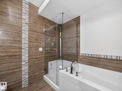 Full bathroom with a garden tub, a stall shower, and tile walls - 