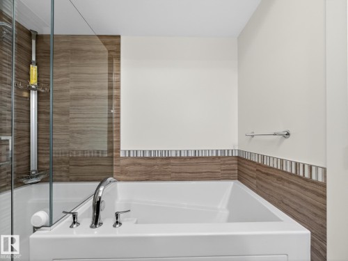 Bathroom featuring a bath and tile walls - 902 11969 Jasper Avenue, Edmonton, AB - Indoor Photo Showing Bathroom