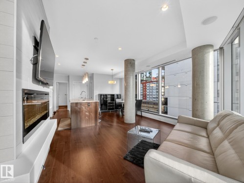 Living room featuring dark wood-style flooring, recessed lighting, and expansive windows - 902 11969 Jasper Avenue, Edmonton, AB - Indoor Photo Showing Living Room With Fireplace