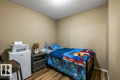 Bedroom with dark wood-style floors and a textured ceiling - 107 25 Element Dr, St. Albert, AB - Indoor Photo Showing Bedroom