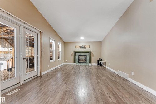 Unfurnished living room with light wood-style floors and a tile fireplace - 6741 162A Avenue, Edmonton, AB - Indoor With Fireplace
