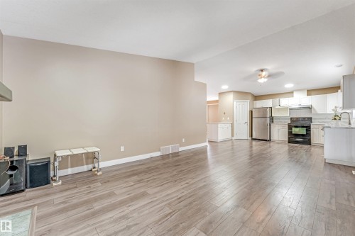 Unfurnished living room with light wood-type flooring, ceiling fan, and recessed lighting - 6741 162A Avenue, Edmonton, AB - Indoor With Fireplace
