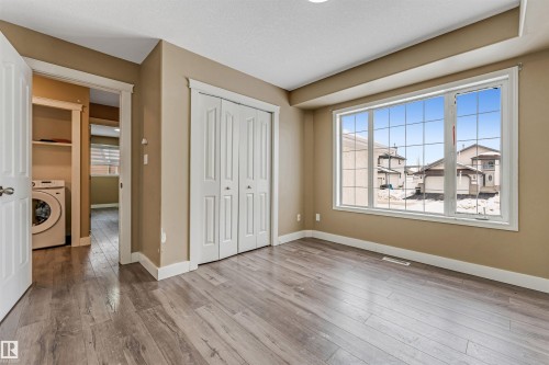 Unfurnished bedroom with washer / clothes dryer, a closet, and light wood-style flooring - 6741 162A Avenue, Edmonton, AB - Indoor