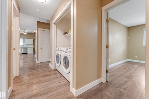 Washroom featuring light wood-style floors, a ceiling fan, and separate washer and dryer - 6741 162A Avenue, Edmonton, AB - Indoor Photo Showing Laundry Room