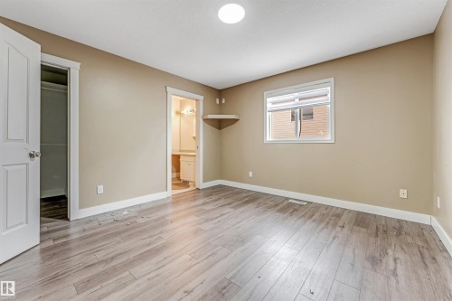 Unfurnished bedroom featuring a spacious closet, light wood-type flooring, and ensuite bathroom - 6741 162A Avenue, Edmonton, AB - Indoor Photo Showing Other Room