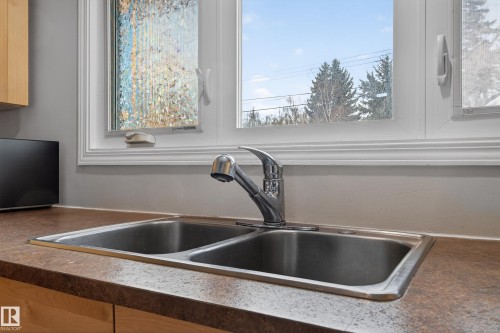 Kitchen view of a sink and dark countertops - 8328 164 Street, Edmonton, AB - Indoor Photo Showing Kitchen With Double Sink