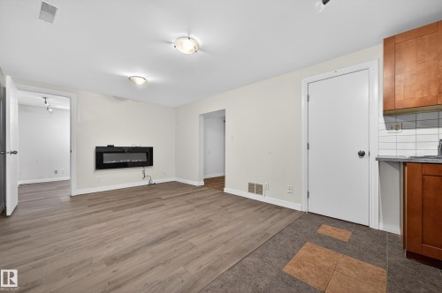 Unfurnished living room featuring dark wood finished floors and baseboards - 8328 164 Street, Edmonton, AB - Indoor With Fireplace
