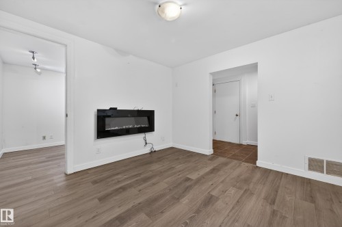 Unfurnished living room with wood finished floors and lofted ceiling - 8328 164 Street, Edmonton, AB - Indoor Photo Showing Living Room With Fireplace