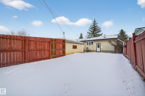 Snow covered house featuring a fenced backyard and stucco siding - 8328 164 Street, Edmonton, AB - Outdoor