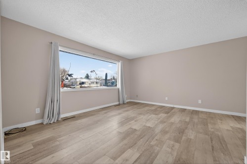 Spare room with light wood finished floors and a textured ceiling - 8328 164 Street, Edmonton, AB - Indoor