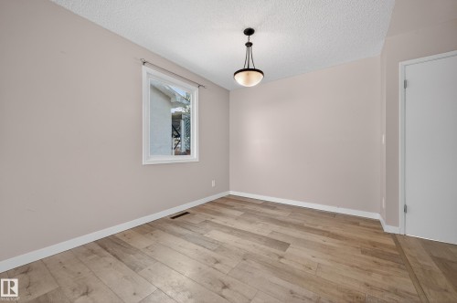 Spare room featuring a textured ceiling and light wood-type flooring - 8328 164 Street, Edmonton, AB - Indoor Photo Showing Other Room