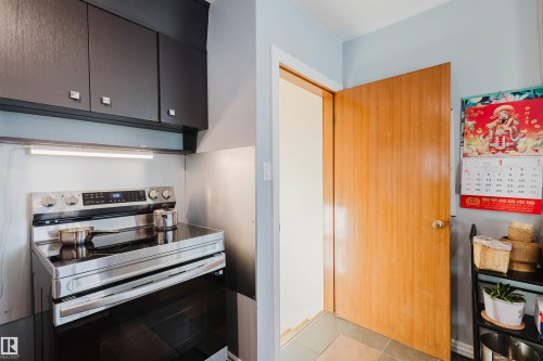 Kitchen with stainless steel electric range oven and light tile patterned flooring - 13315 134 Avenue, Edmonton, AB - Indoor Photo Showing Kitchen