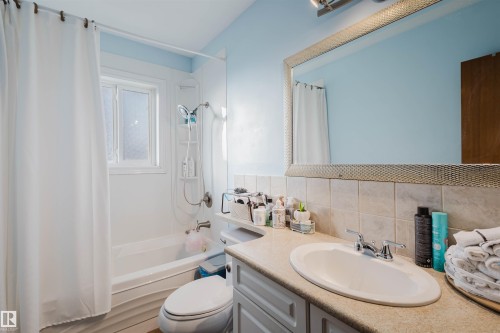Bathroom featuring vanity, shower / bath combo, and tasteful backsplash - 13315 134 Avenue, Edmonton, AB - Indoor Photo Showing Bathroom