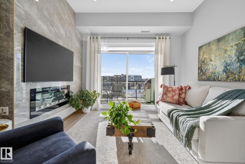 401 7471 May Common, Edmonton, AB - Indoor Photo Showing Living Room With Fireplace